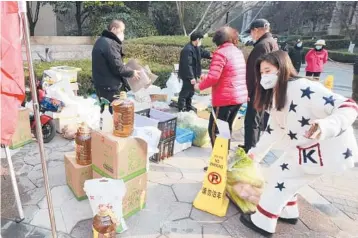  ?? CHINATOPIX ?? Residents shop for food at a temporary store Monday in Xi’an, a city under lockdown in China’s Shaanxi province.