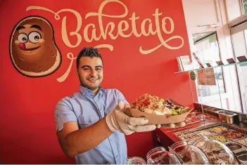  ?? RP-FOTO: HANS-JÜRGEN BAUER ?? Mitarbeite­r Duran Kilic bereitet in einer Baketato-Filiale eine Kartoffel „Athen“vor.