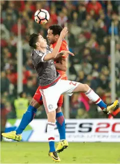  ??  ?? El paraguayo Miguel Almiron y el chileno Jean Beausejour saltan durante el juego de ayer en Santiago.