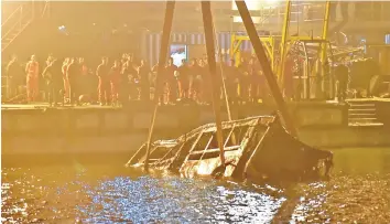  ?? — AFP photo ?? A crane salvages the wreckage of a bus after it plunged off a bridge into the Yangtze River in China’s southweste­rn Chongqing.