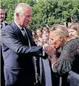  ?? ?? A well-wisher kisses the hand of King Charles III during a walkabout outside Buckingham Palace yesterday. | REUTERS