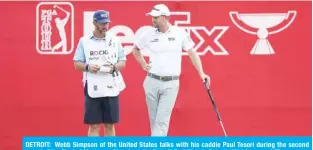  ??  ?? DETROIT: Webb Simpson of the United States talks with his caddie Paul Tesori during the second round of the Rocket Mortgage Classic at the Detroit Golf Club in Detroit, Michigan. — AFP