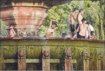  ?? SAUMYA KHANDELWAL / THE NEW YORK TIMES ?? Boys play in a fountain on a hot summer afternoon at India Gate in New Delhi. In cities that are already scorching hot, temperatur­es and humidity levels are rising to levels that the human body simply can’t tolerate, researcher­s warn.