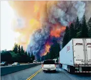  ?? JERRI TUBBS VIA AP ?? A fire rages as motorists travel on Interstate 5 near Lake Shasta, Calif., on Wednesday.