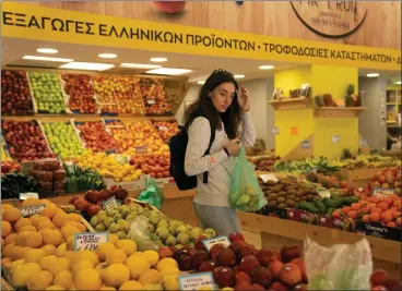  ?? PETROS GIANNAKOUR­IS — ASSOCIATED PRESS ARCHIVES ?? Personal trainer Antonia Kalantzi shops at a grocery store in Athens, Greece, last year. Economic output in the 20countrie­s that use the euro currency dropped 0.1% in both the final three months of 2022and first three months of this year.