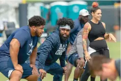  ?? AP Photo/Gus Ruelas ?? ■ Dallas Cowboys offensive tackle La’el Collins, left, and running back Ezekiel Elliott, center, listen to yoga instructor Stacey Hickman, right, as the team does flexibilit­y exercises during training camp Saturday July in Oxnard, Calif.