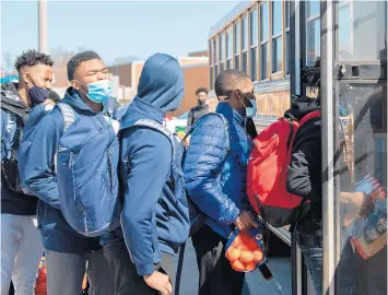  ?? KYLE TELECHAN/POST-TRIBUNE ?? West Side Leadership Academy basketball players board a bus Friday before departing for their semistate game.