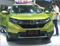 ??  ?? Visitors look at a Honda CR-V at an auto show in Dongguan, Guangdong province.
