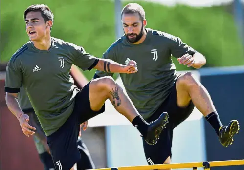  ?? — AFP ?? Moving forward: Striker Paulo Dybala (left) and Gonzalo Higuain taking part in Juventus’ training session in Turin yesterday. Juventus face Barcelona in the Champions League today.