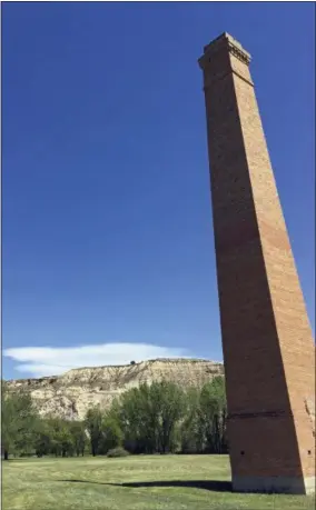  ?? BLAKE NICHOLSON— THE ASSOCIATED PRESS ?? In this Wednesday, May 24photo, a smokestack from an Old West-era meatpackin­g plant is shown in Theodore Roosevelt National Park in western North Dakota. The park is known for hills, ridges, buttes and bluffs where millions of years of erosion have...