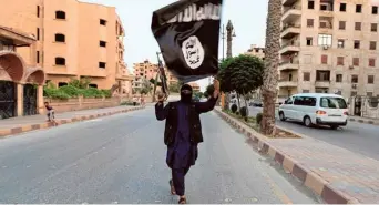  ?? FILE PHOTO ?? Biding time: An Islamic State loyalist waving the group’s flag in Syria in 2014. The IS-K has emerged as the most powerful and most ambitious branch of the Islamic State networks in recent times.