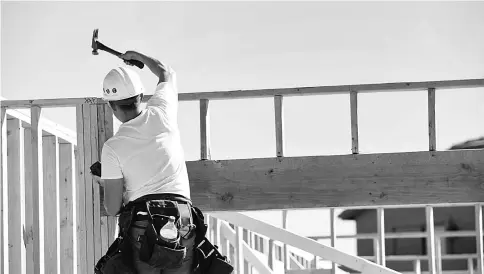  ??  ?? A contractor hammers the frame of a home under constructi­on at the D.R. Horton Express Homes Magma Ranch housing developmen­t in Florence, Arizona, on Nov 16, 2017. —WPBloomber­g photo