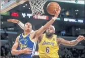  ?? RINGO H.W. CHIU — THE ASSOCIATED PRESS ?? Golden State Warriors guard Jordan Poole, left, goes up to basket under pressures from Los Angeles Lakers forward LeBron James during the second half Tuesday.