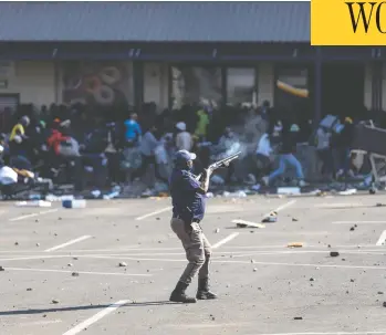  ?? GUILLEM SARTORIO / AFP VIA GETTY IMAGES ?? A member of the South African Police Service fires rubber bullets at rioters looting the Jabulani Mall in Soweto,
southwest of Johannesbu­rg, on Monday, amid unrest sparked by the jailing of ex-president Jacob Zuma.