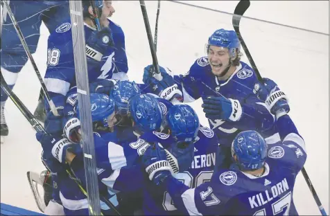  ?? — DAN HAMILTON/USA TODAY SPORTS ?? Tampa Bay Lightning players celebrate Brayden Point’s game-winning goal against the Columbus Blue Jackets in the fifth overtime of the opening game of their Eastern Conference playoff series on Tuesday.