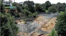  ?? ABIGAIL DOUGHERTY/STUFF ?? Left: Kyle Aitken stands in the scoured-out boatyard, where a surge of water raced through. Above: The tennis court copped the brunt of one of the many slips from the surroundin­g cliffs.
Right: Bowls club treasurer Shaun Bayne amid the clean-up effort.