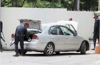  ??  ?? GUARDIAS paquistaní­es revisan un vehículo en las inmediacio­nes del consulado estadounid­ense en Lahore, que fue evacuado por una amenaza.