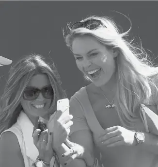  ?? Andrew Redington/afp/getty Images ?? Nadine Moze and Lindsey Vonn laugh as they watch their partners Fred Couples and Tiger Woods, respective­ly, on Wednesday ahead of the 142nd British Open Championsh­ip.