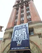  ?? MICHAEL SEARS / MILWAUKEE JOURNAL SENTINEL ?? A large Brewers playoff banner hangs on Milwaukee City Hall.