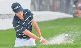  ??  ?? Justin Thomas chips out of a bunker on his way to a 65.