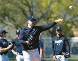  ?? DAVID J. PHILLIP/AP ?? New York Yankees pitcher Carlos Rodon throws to first during a spring training workout Feb. 18 in Tampa, Fla.