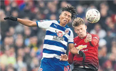  ?? OLI SCARFF AFP/GETTY IMAGES ?? Reading striker Danny Loader, left, and Manchester United midfielder Scott McTominay go up for a header on Saturday.