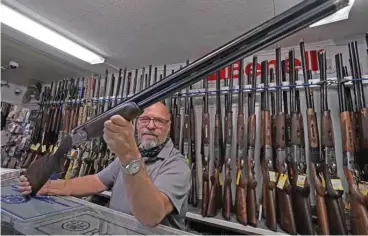  ?? (aFP) ?? This file photo shows salesman Paul Fraker showing off weapons for sale at Coliseum Gun Traders Ltd. in Uniondale, New York on October 1, 2020