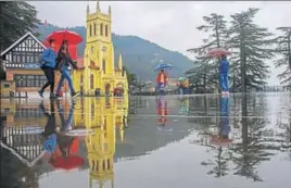  ?? PTI ?? ■ People walk on The Ridge as it rains in Shimla on Saturday.