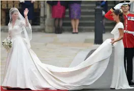  ??  ?? Kate Middleton waves to the crowds as her sister and maid of honour Pippa Middleton holds her dress on her wedding day in April 2011. Photo: Getty