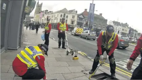  ??  ?? TODO AL DETALLE. Agentes rastrearon ayer el subsuelo de la ciudad, se instalaron barreras que impedirán el paso de vehículos pesados donde haya aglomeraci­ones de gente.