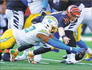  ?? Michael Conroy Associated Press ?? UCHENNA NWOSU dives to recover a fumble by Bengals quarterbac­k Joe Burrow. Nwosu also finished with two of the Chargers’ six sacks as the defense went blitz-heavy without Joey Bosa following Bosa’s concussion.