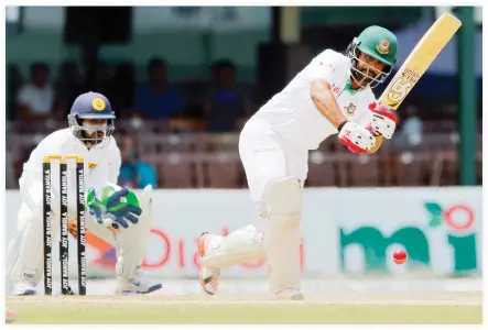  ??  ?? Bangladesh's Tamim Iqbal plays a shot as Sri Lanka's wicketkeep­er Niroshan Dickwella watches on day-five of their second Test match in Colombo on Sunday. (AP)