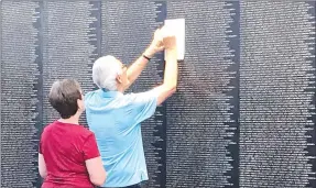  ?? PHOTOS BY SALLY CARROLL/MCDONALD COUNTY PRESS ?? Those with loved ones and friends who died in the Vietnam War were able to rub their name onto a piece of paper at The Wall That Heals traveling exhibit. The replica of the Vietnam Veterans Wall lists all the names of the those who died during the Vietnam War.