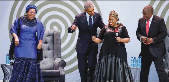  ??  ?? Former US president Barack Obama , Graca Machel (left), widow of former South African president and global icon Nelson Mandela, and South African President Cyril Ramaphosa (right) dance as South African singer Thandiswa Mazwai (second right) performs during the 2018 Nelson Mandela Annual Lecture at the Wanderers cricket stadium in Johannesbu­rg, yesterday.
