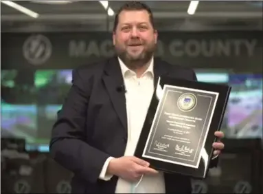  ?? COURTESY FACEBOOK LIVE ?? Macomb County Health Department Director/Health Officer Andrew Cox receives an accreditat­ion plaque from the Public Health Accreditat­ion Board.
