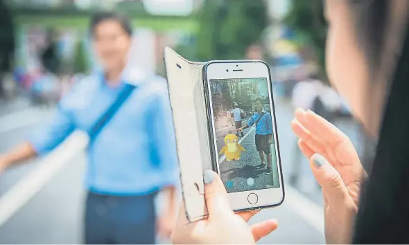 ?? N. HAYASHI / BLOOMBERG ?? Una dona juga a Pokémon Go amb el mòbil als carrers de Tòquio el mes de juliol passat