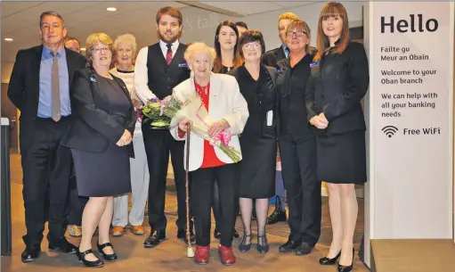  ??  ?? Caroline Jamieson, aged 100, was presented with flowers after she cut the tape to open the RBS branch in Oban.