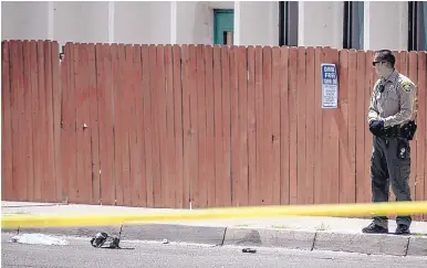  ?? ROBERTO E. ROSALES/JOURNAL ?? A Bernalillo County Sheriff’s deputy stands next to what looks like a gun and a small bundle of clothes at the scene of a shooting involving deputies Monday.