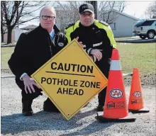  ?? ALEX PEDERSEN SPECIAL TO THE ST. CATHARINES STANDARD ?? Peter Van Hezewyk, CAA Niagara president and CEO, and Romolo Di Egidio, Niagara Regional Police staff sergeant, kneel beside a pothole on St. David’s Road in Thorold.