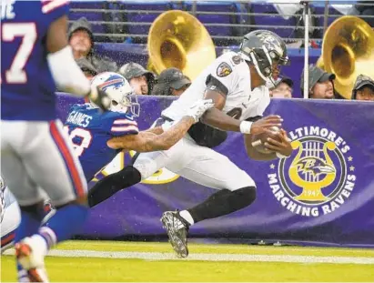  ?? KENNETH K. LAM/BALTIMORE SUN ?? The Ravens’ Lamar Jackson, right, runs for 16 yards before he is forced out of bounds by the Bills’ Phillip Gaines at the 2-yard-line in the fourth quarter. Jackson completed one of four passes for 24 yards and ran seven times for 39 yards in his debut.