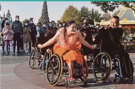  ?? AFP PIC ?? Wheelchair dancers from the Shanghai Oriental Pearl TV Tower Handicappe­d Art Troupe performing at Shanghai Disneyland on Dec 3, the Internatio­nal Day of Persons with Disabiliti­es.