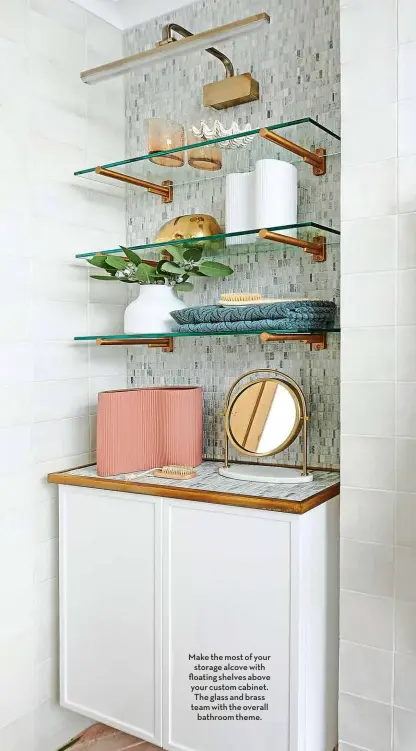  ?? ?? Make the most of your storage alcove with floating shelves above your custom cabinet. The glass and brass team with the overall bathroom theme.