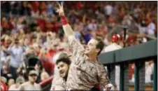  ?? JOHN MINCHILLO — THE ASSOCIATED PRESS ?? Scooter Gennett, center, is lifted up by Eugenio Suarez as he celebrates in the dugout during the eighth inning against the St. Louis Cardinals Tuesday in Cincinnati.