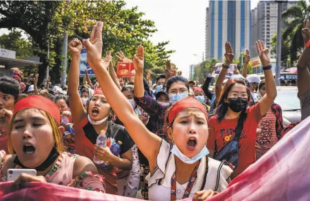  ?? Getty Images ?? Demonstrat­ors march in Yangon to protest the military junta that seized power and detained de facto leader Aung San Suu Kyi.