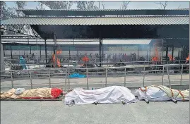  ?? AFP ?? Bodies of Covid-19 coronaviru­s victims lined up before cremation at a cremation ground in New Delhi.