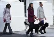  ?? SUSAN WALSH — THE ASSOCIATED PRESS FILE ?? First lady Michelle Obama, left, follows her daughters Malia Obama, holding the leash for Bo, center, and Sasha Obama, holding the leash for Sunny, as they arrive to welcome the Official White House Christmas Tree to the White House in Washington.