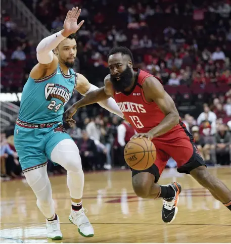  ?? AP ?? WEARING OUT THE ROCK: James Harden (right) drives toward the basket during the Rockets win over Memphis.