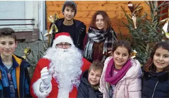  ??  ?? Des enfants heureux sur la place devant le chalet du Père Noël.