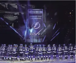  ?? AP ?? Lightning players look on as their 2019-2020 Stanley Cup Champions banner is revealed on Wednesday in Tampa, Fla.