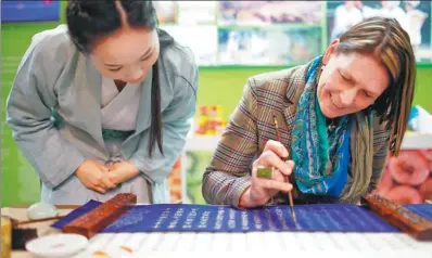  ?? ZHANG FAN / XINHUA ?? A local woman experience­s the art of traditiona­l Chinese calligraph­y at China booth at a fair promoting green lifestyle along the Belt and Road Initiative economies in Berlin in January 2015.
Jim O'Neill, renowned economist and coiner of the term “BRIC”